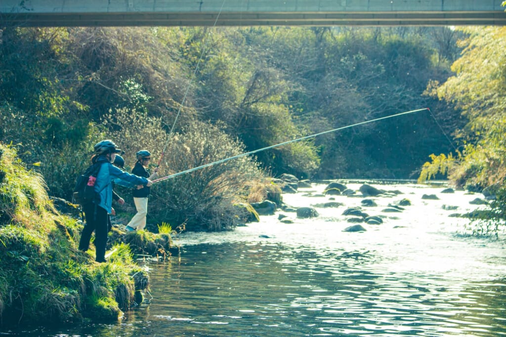 那比川で渓流釣りをする女性